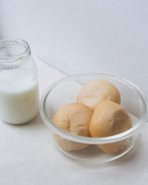 Free A Glass of Milk and Breads on Clear Bowl Stock Photo