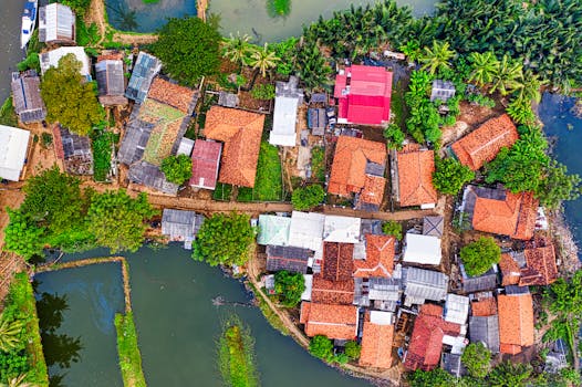 Colorful aerial view of traditional village houses surrounded by greenery and water in Banten, Indonesia.