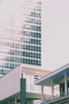 From below of exterior of building with glass facade and big windows in geometric design in downtown of city