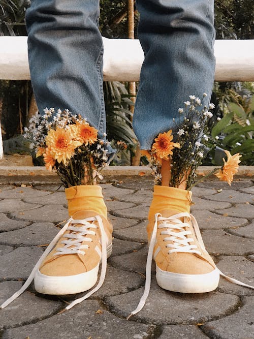 Close-Up Photo of a Person Wearing Yellow Shoes with Flowers