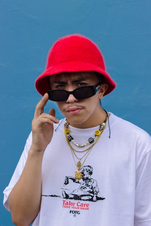 Photo of a Man with a Red Bucket Hat Looking at the Camera 