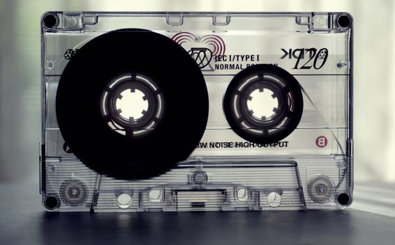 Close-up shot of a vintage cassette tape, highlighting nostalgic retro design and text details.