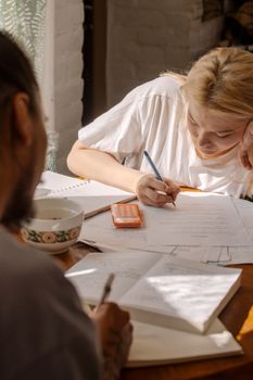 两个学生正专注于他们的家庭作业、课本和笔记