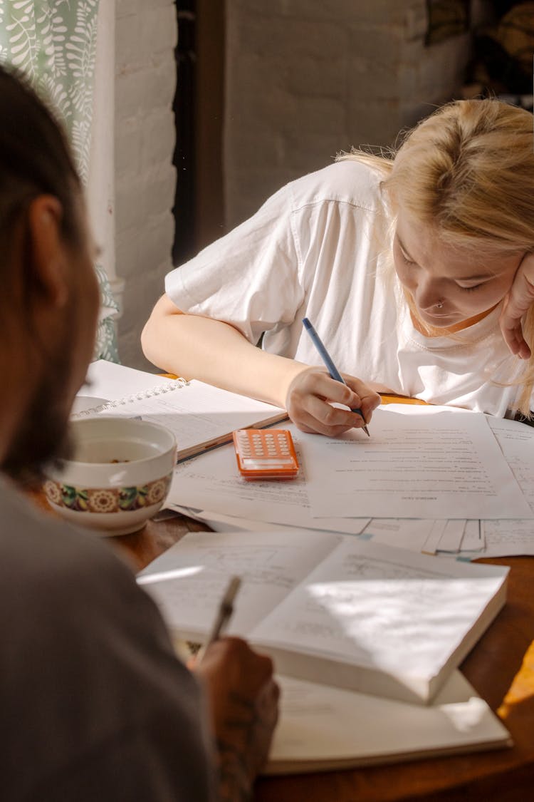 Woman In White Shirt Writing On White Paper