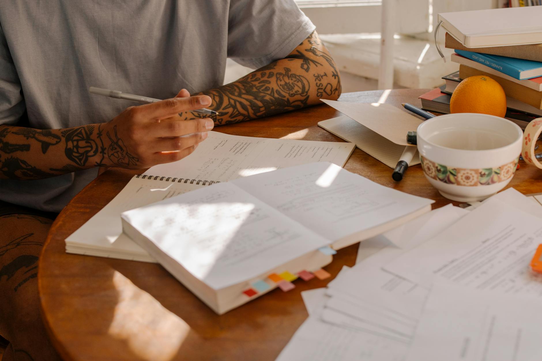 Person in White Long Sleeve Shirt Writing on White Paper