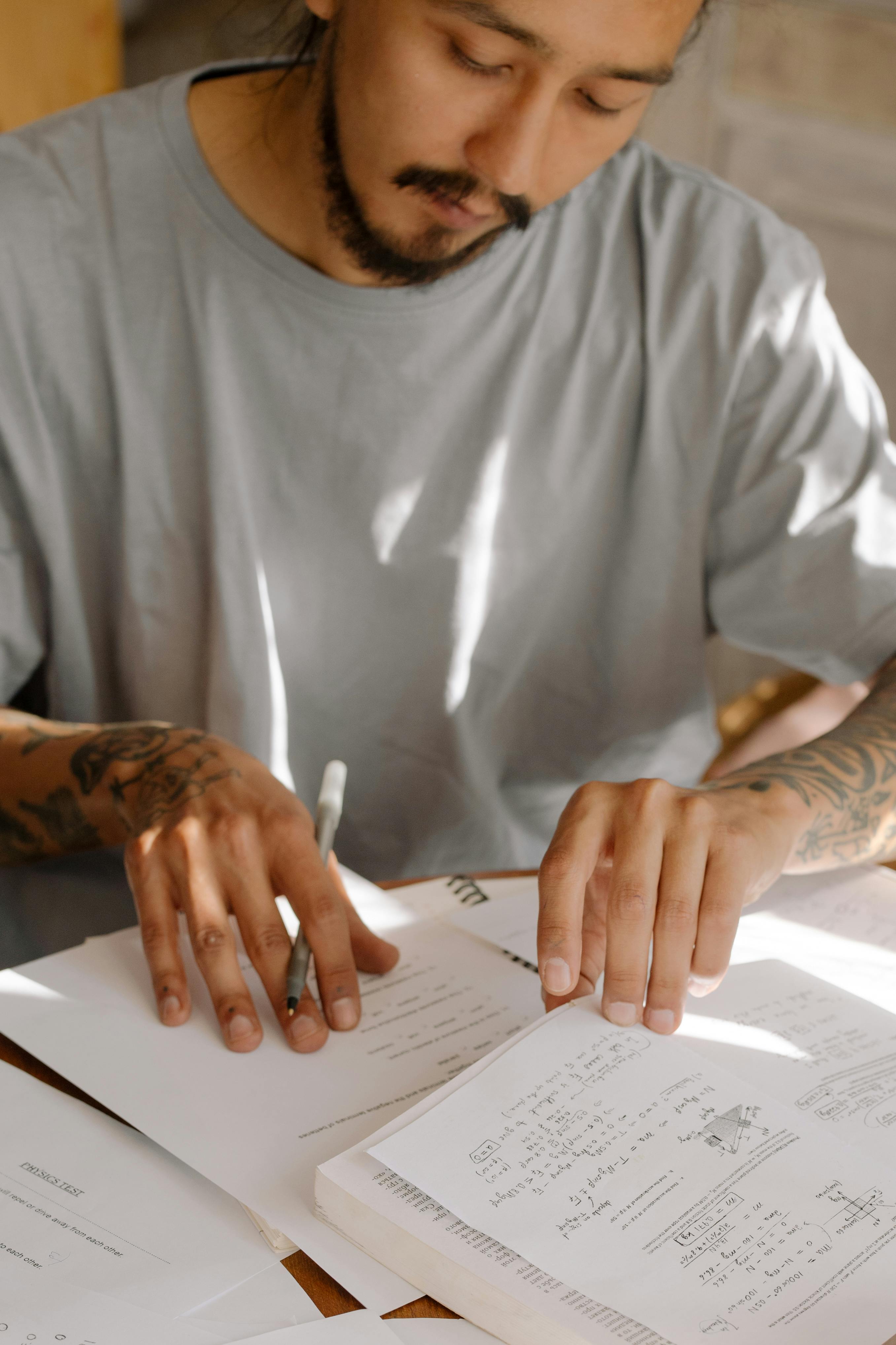 man in white crew neck t shirt holding white printer paper