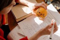 学生在室内温暖的光线下，用橙子和笔记创造性地学习数学