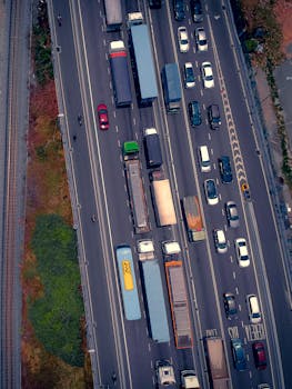 Highway with heavy traffic, cars and trucks, aerial shot showing busy road conditions.