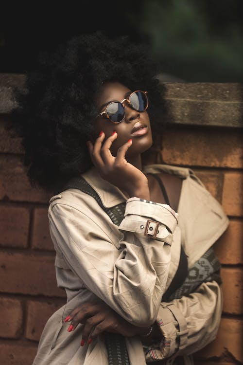 Photo of a Woman with Afro Hair Posing with Her Hand on Her Cheek