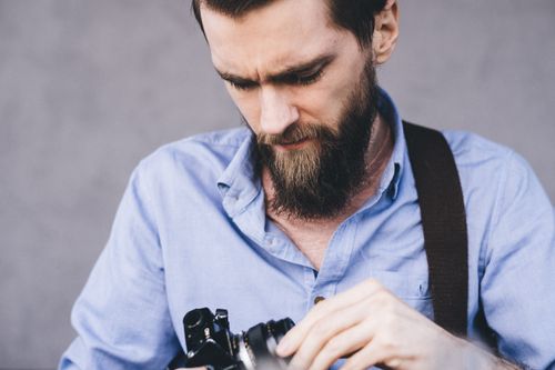Free Close-up of a photographer adjusting camera settings outdoors. Stock Photo