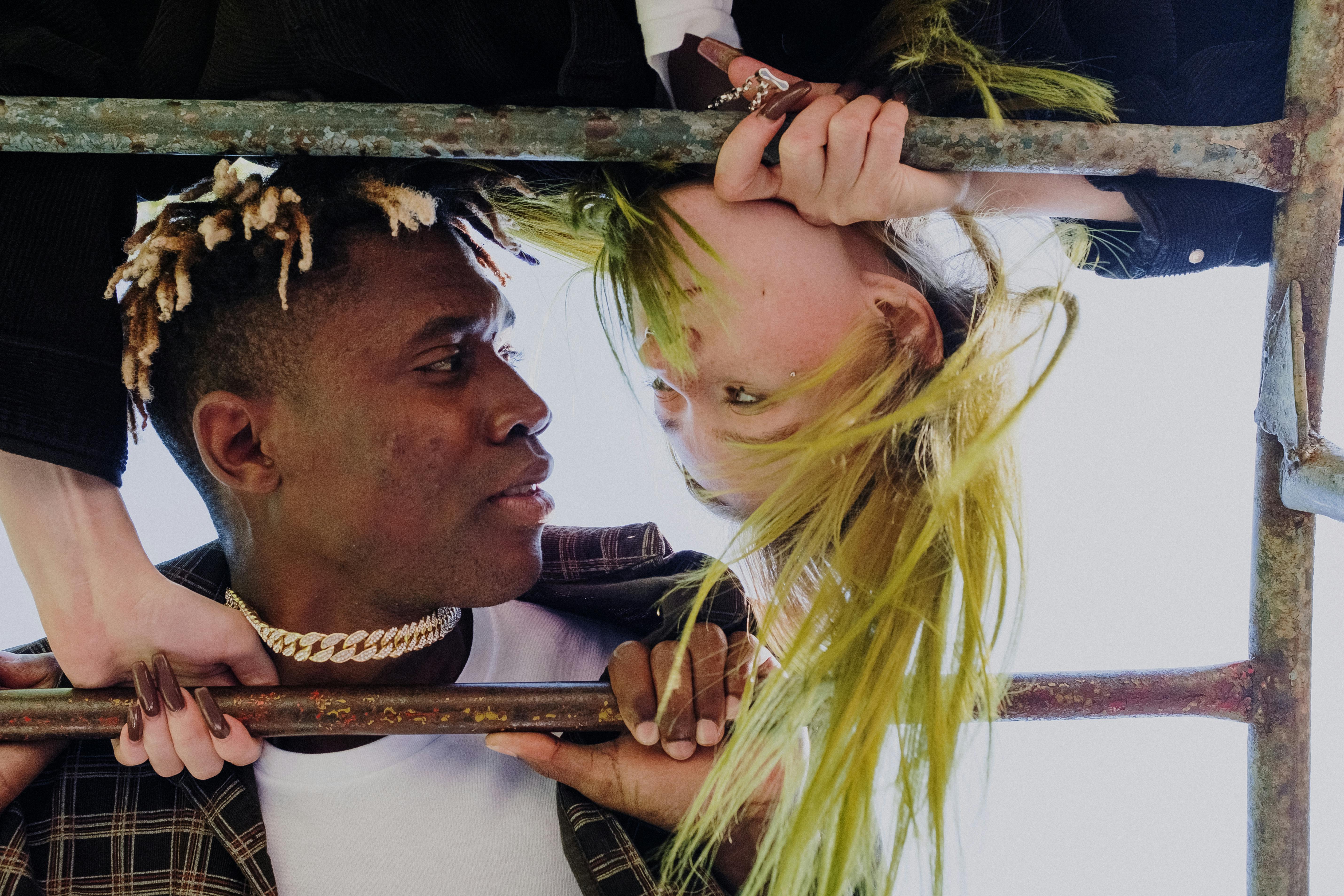 Close-up of a modern couple on a playground bar showing affection and style.