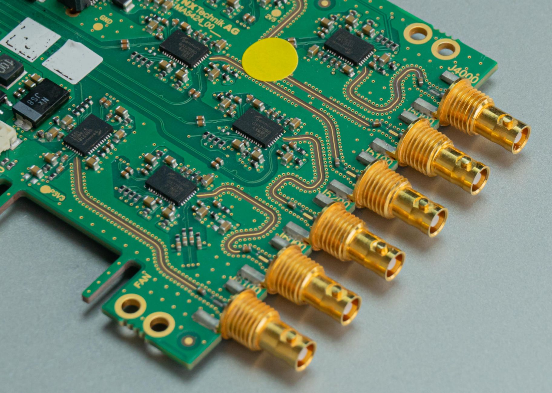 Detailed view of a green circuit board featuring multiple connectors and intricate components.