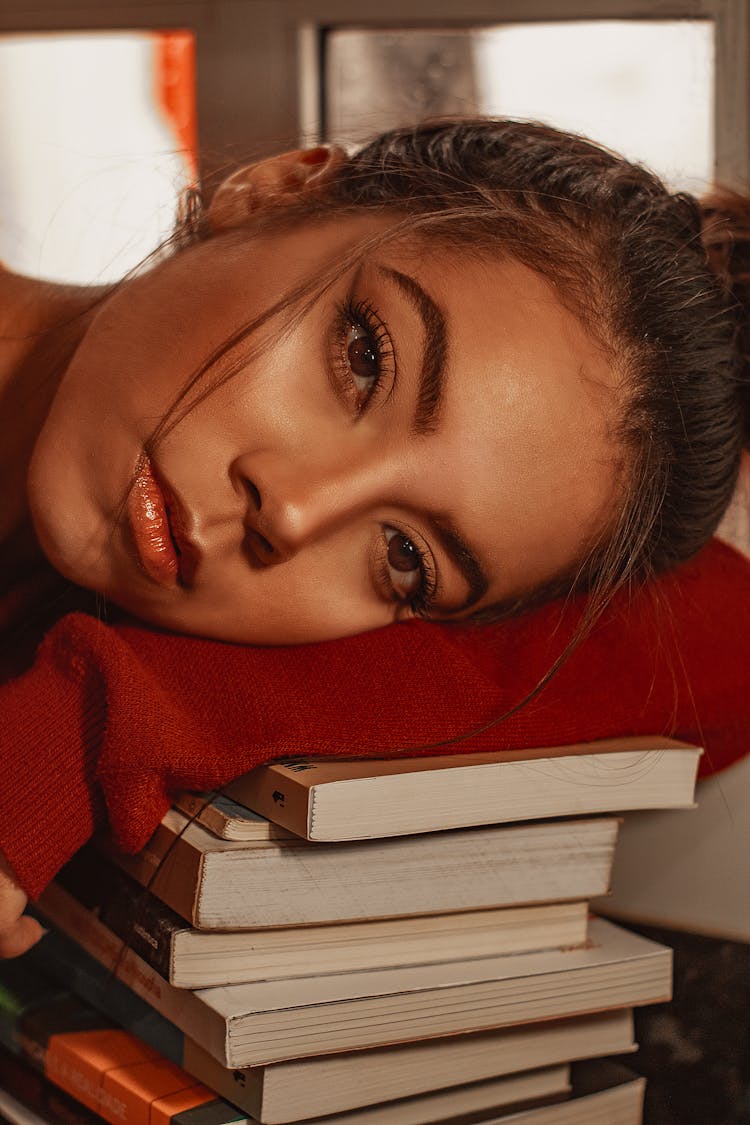 Beautiful Woman Leaning On A Pile Of Books