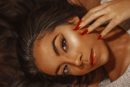 Free Striking close-up portrait of a woman with red nails and beautiful makeup. Stock Photo
