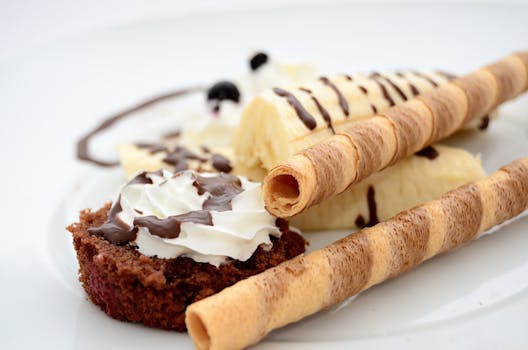 Indulgent dessert featuring chocolate, bananas, and whipped cream on a pastry.