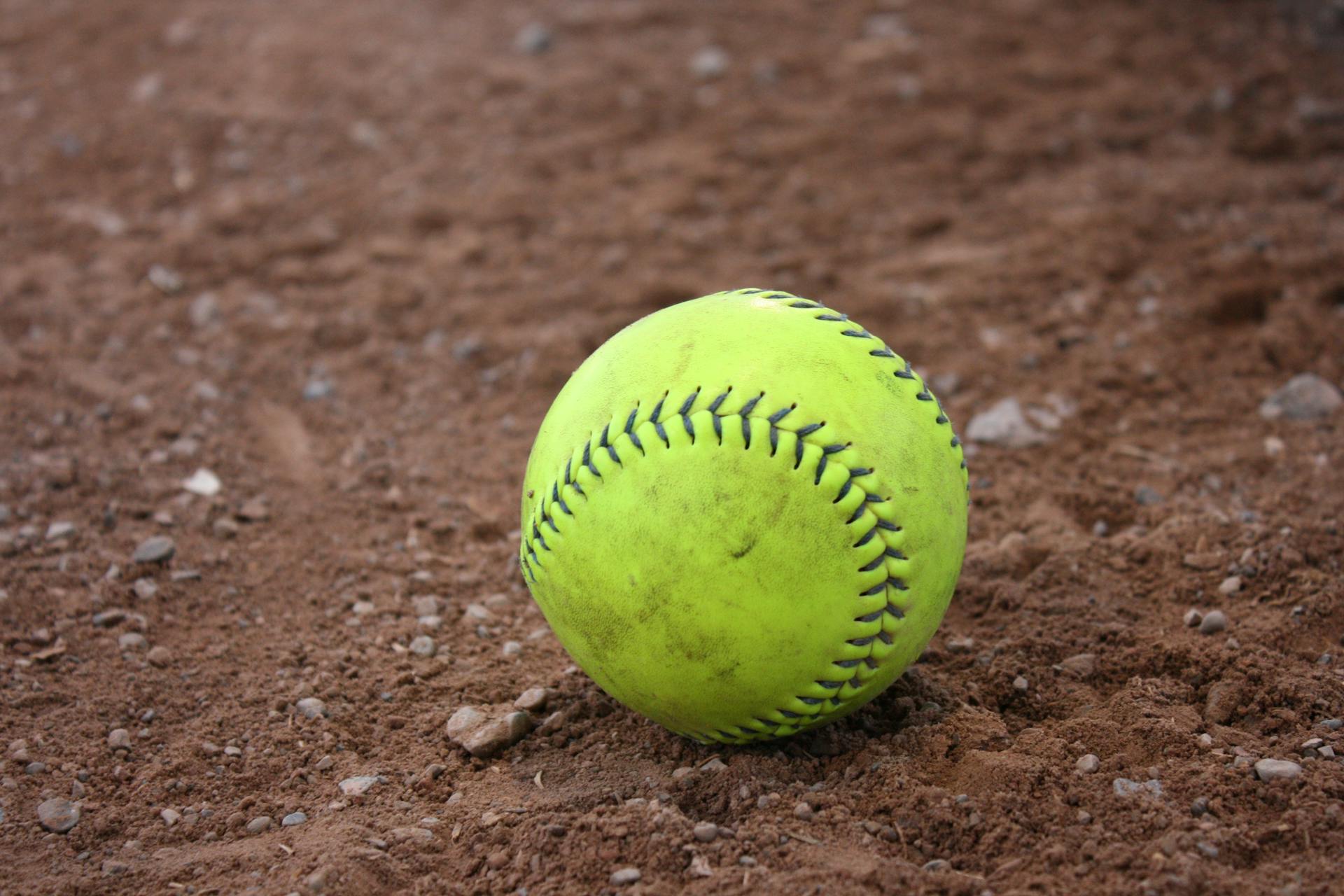 Yellow and Black Tennis Ball in Brown Soil