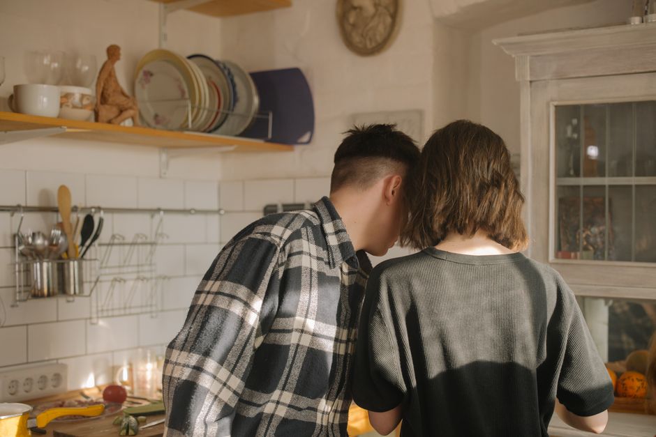 Una coppia si diverte a cucinare insieme in una cucina calda e accogliente.