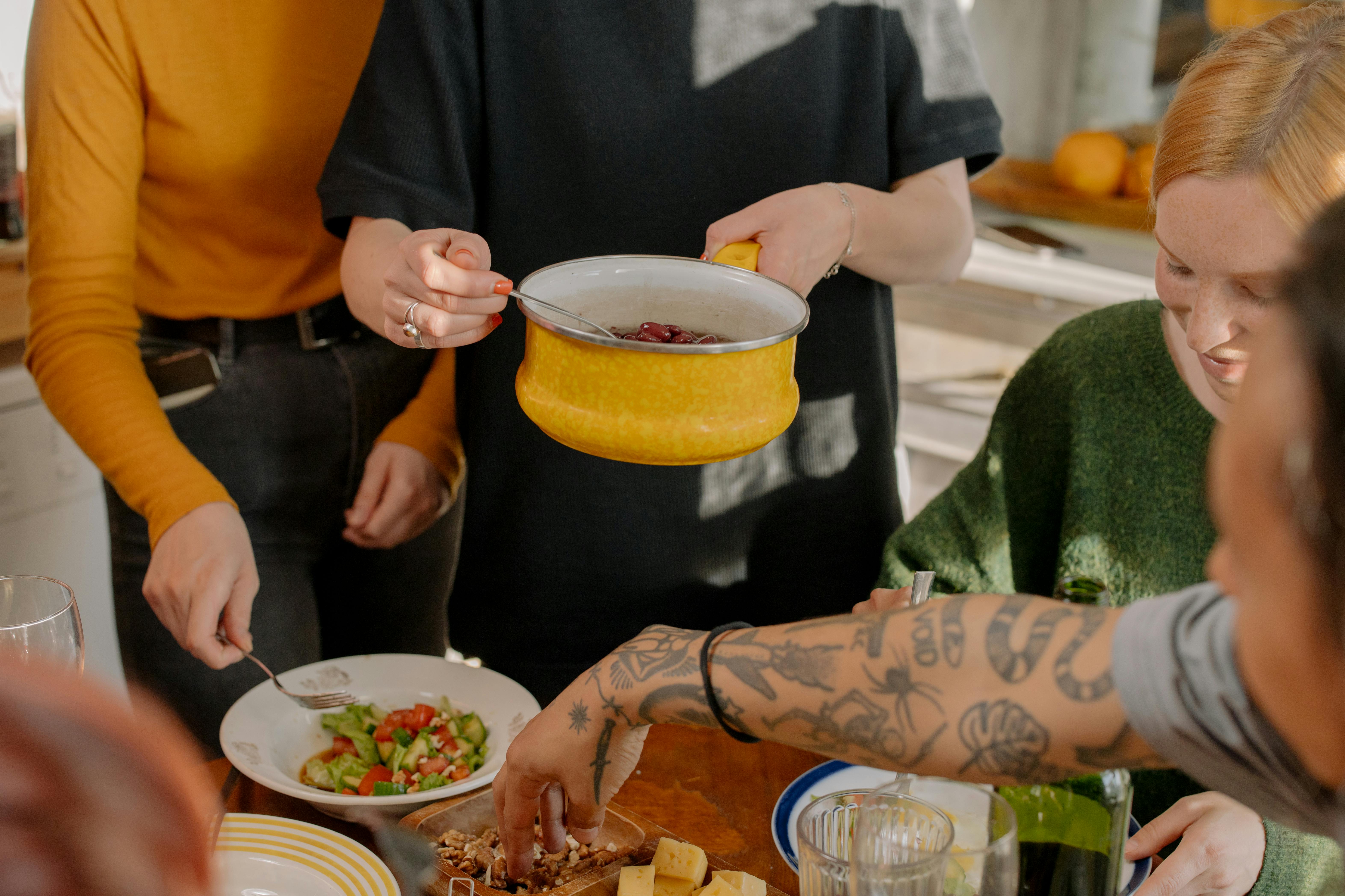 A group of friends enjoying a veggie meal together in a bright kitchen setting.