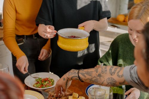 Free A group of friends enjoying a veggie meal together in a bright kitchen setting. Stock Photo