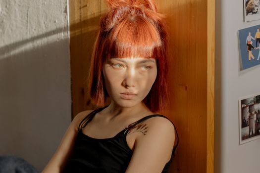 一位红发体贴的女人坐在阳光明媚的房间里，凝视着远方，陷入沉思