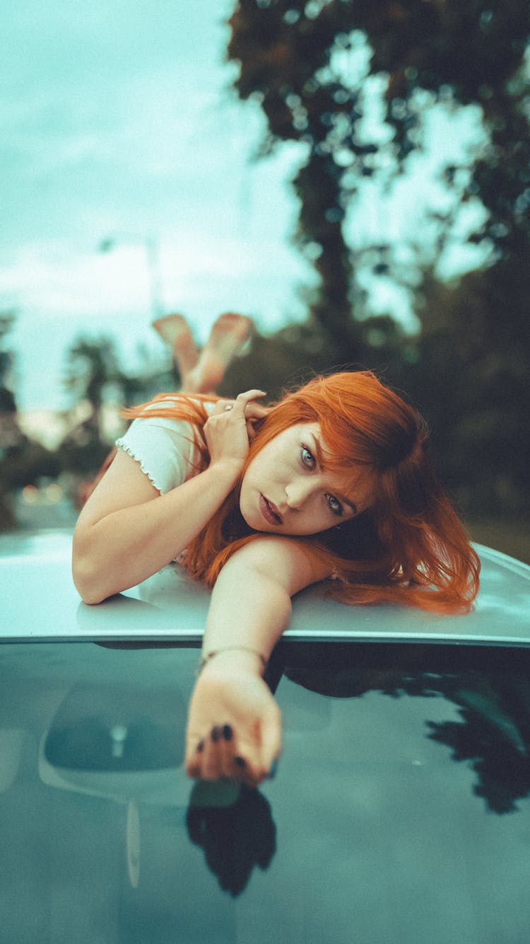 Charismatic Woman Lying On Roof Of Car