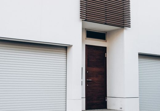 Home with a wooden front door and two garage doors