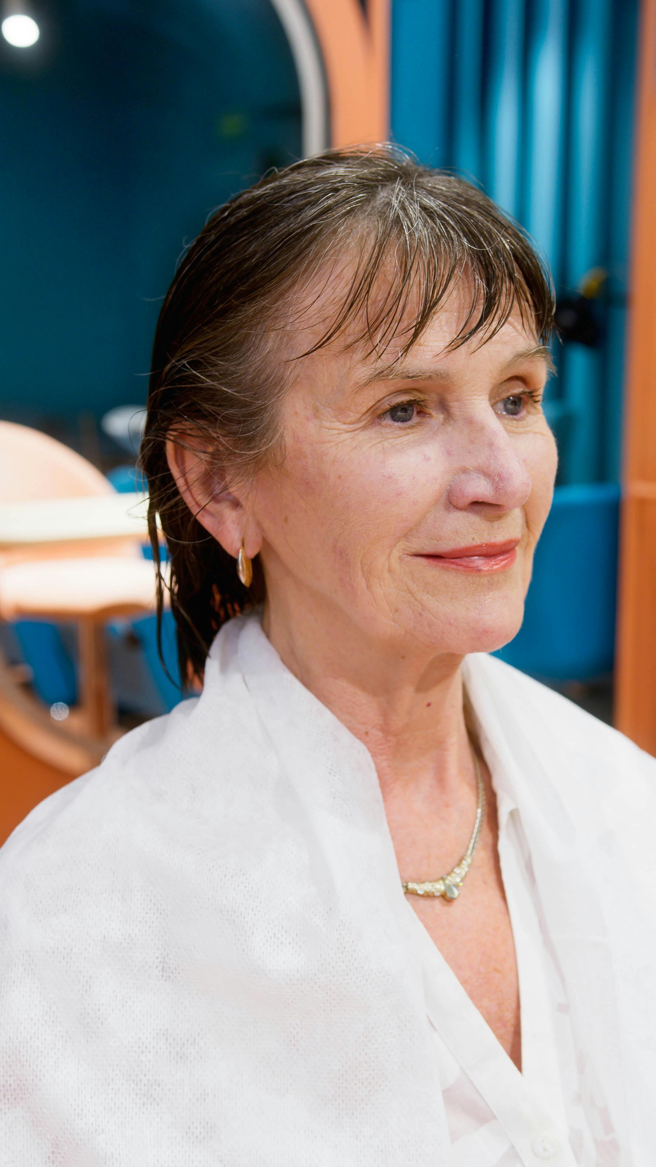 Senior woman enjoying a peaceful moment in a modern beauty salon, embodying pampering and relaxation.