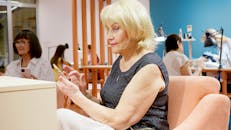 在充满活力的沙龙环境中，老年妇女们使用着智能手机