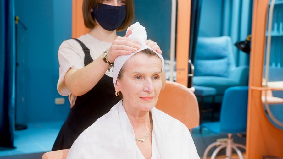 Stylist blow-drying client hair in a luxury salon setting