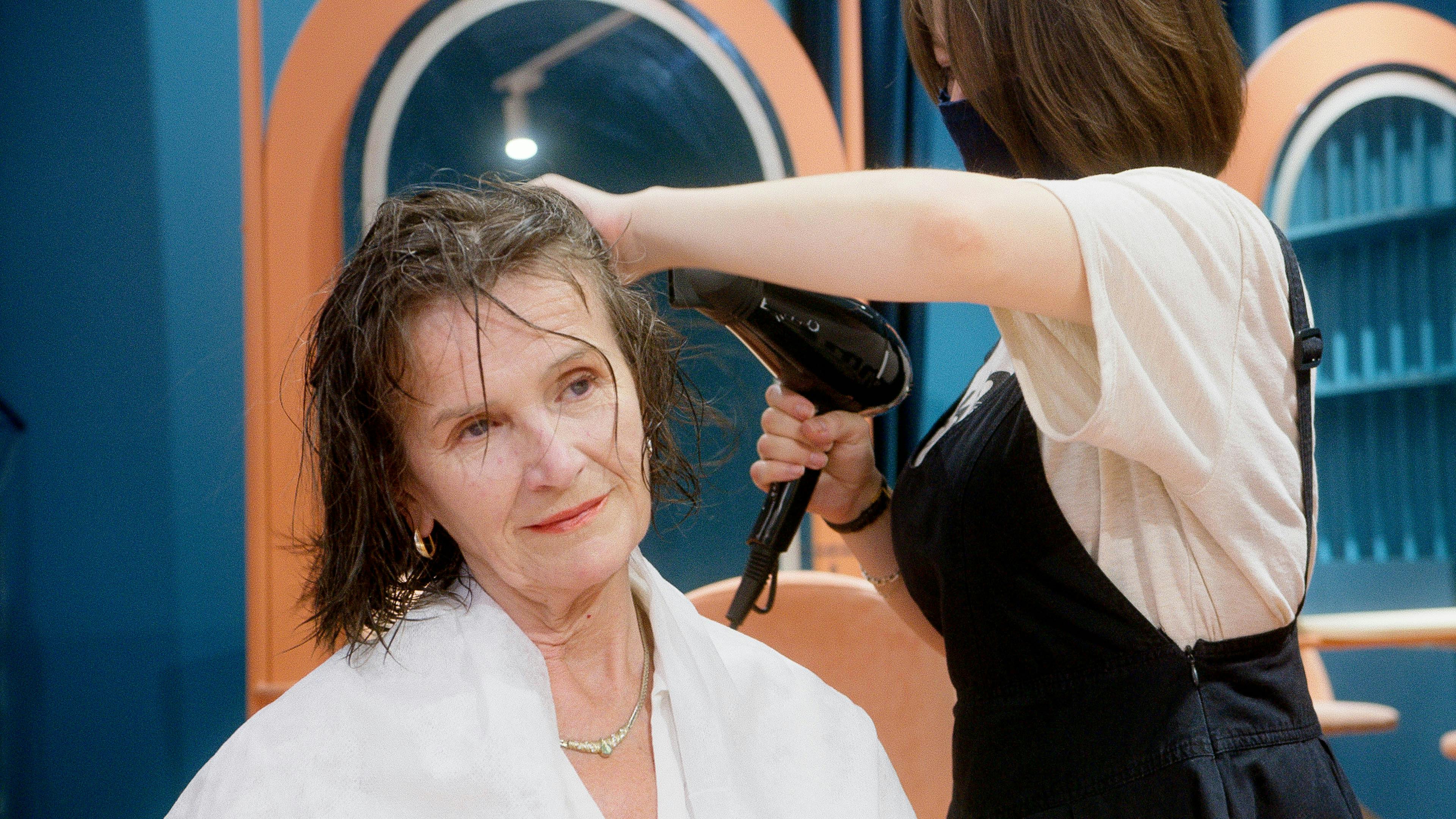 a hairdresser drying a client s hair