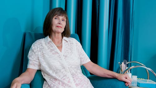 Elderly Woman Sitting on a Blue Armchair