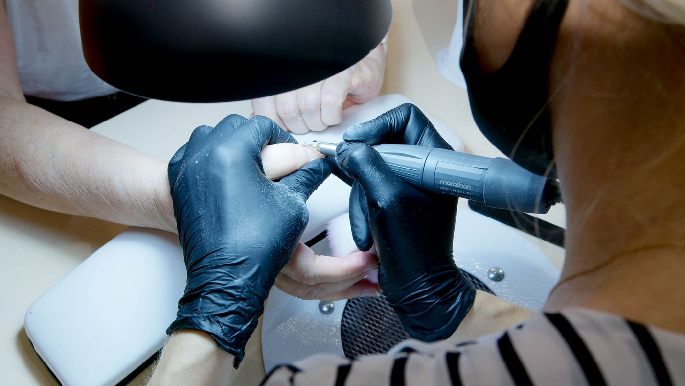 Professional nail technician working carefully on fingernails