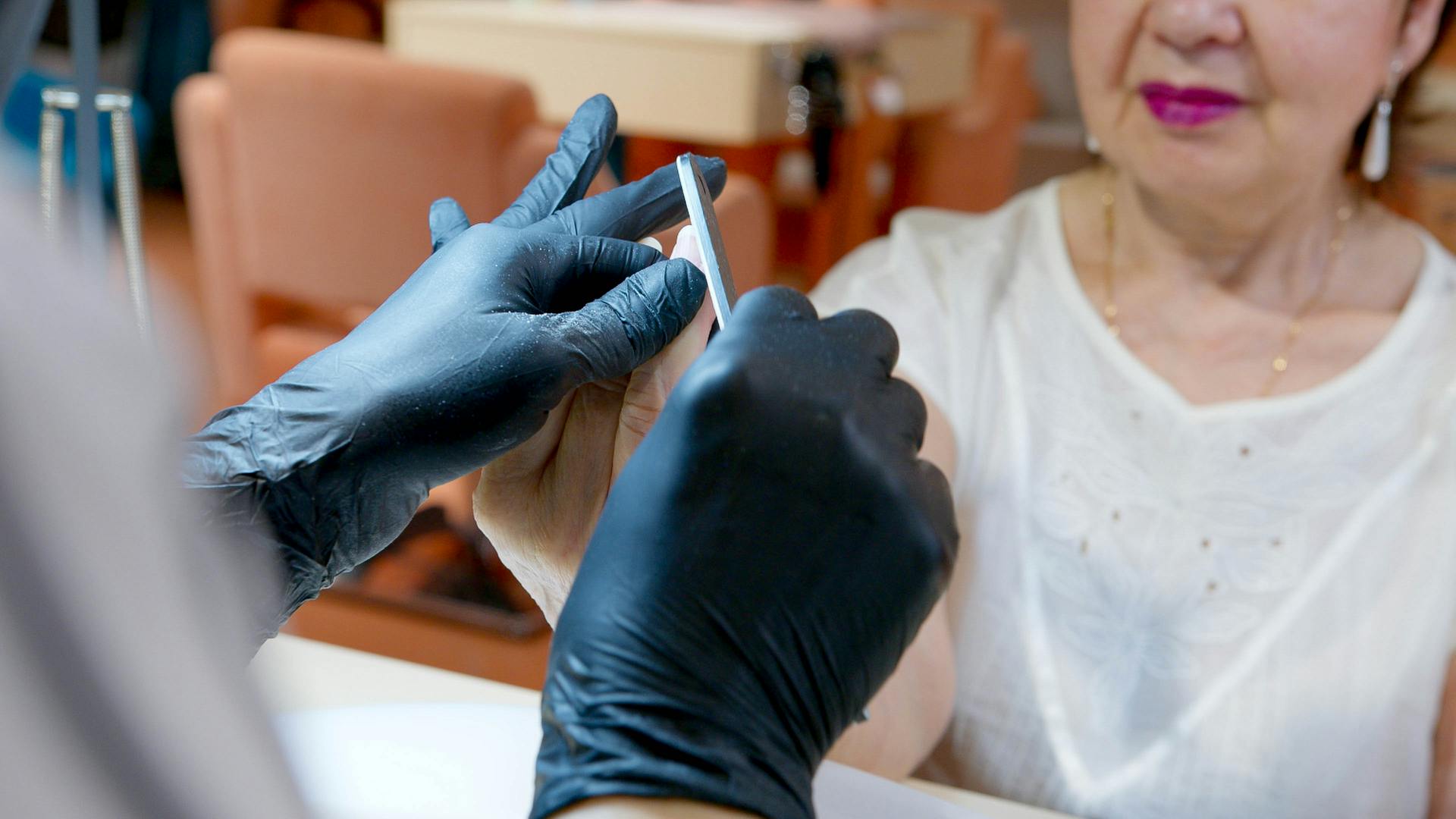 Manicurist Filing an Elderly Woman's Nails