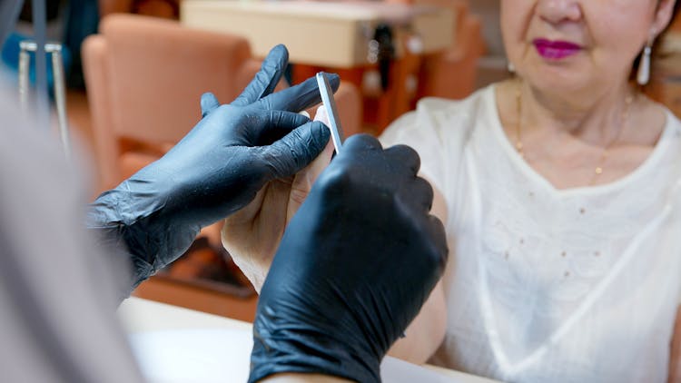 Manicurist Filing An Elderly Woman's Nails