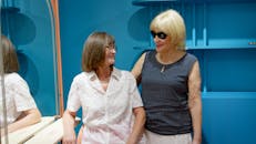 两位资深女性在一家现代沙龙里微笑着，享受着彼此的陪伴