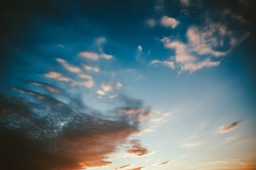 From below scenic view of sky with bright stratus clouds at sundown