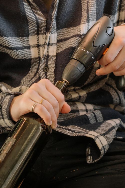 Free Close-up of hands using a drill to open a wine bottle, showcasing ingenuity. Stock Photo