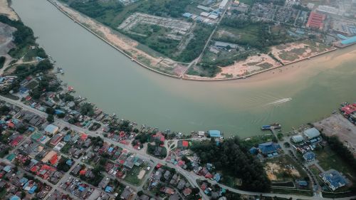 Free Wonderful aerial view of long river running along small settlement with residential houses Stock Photo