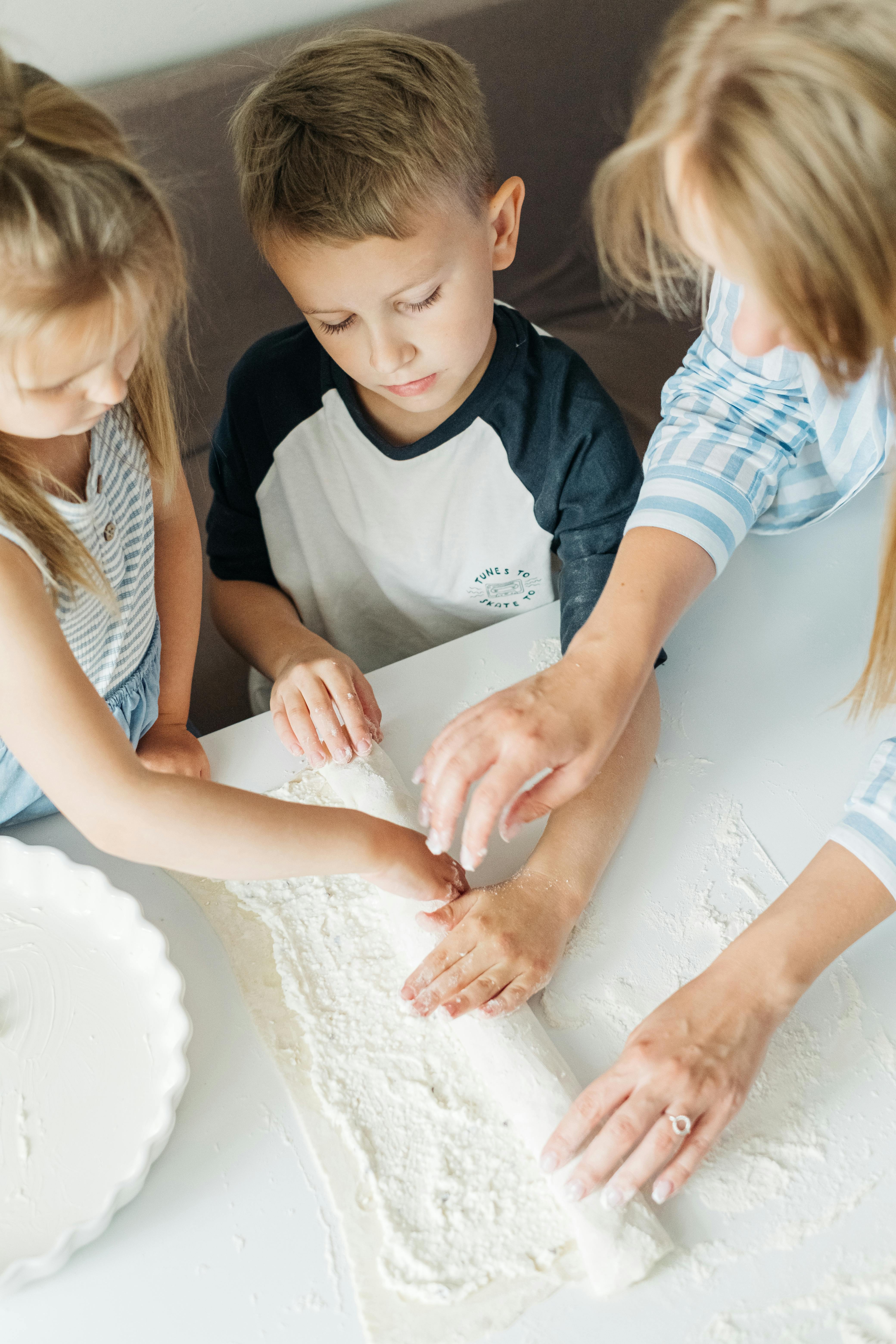 girl in white and black crew neck t shirt holding white round cake