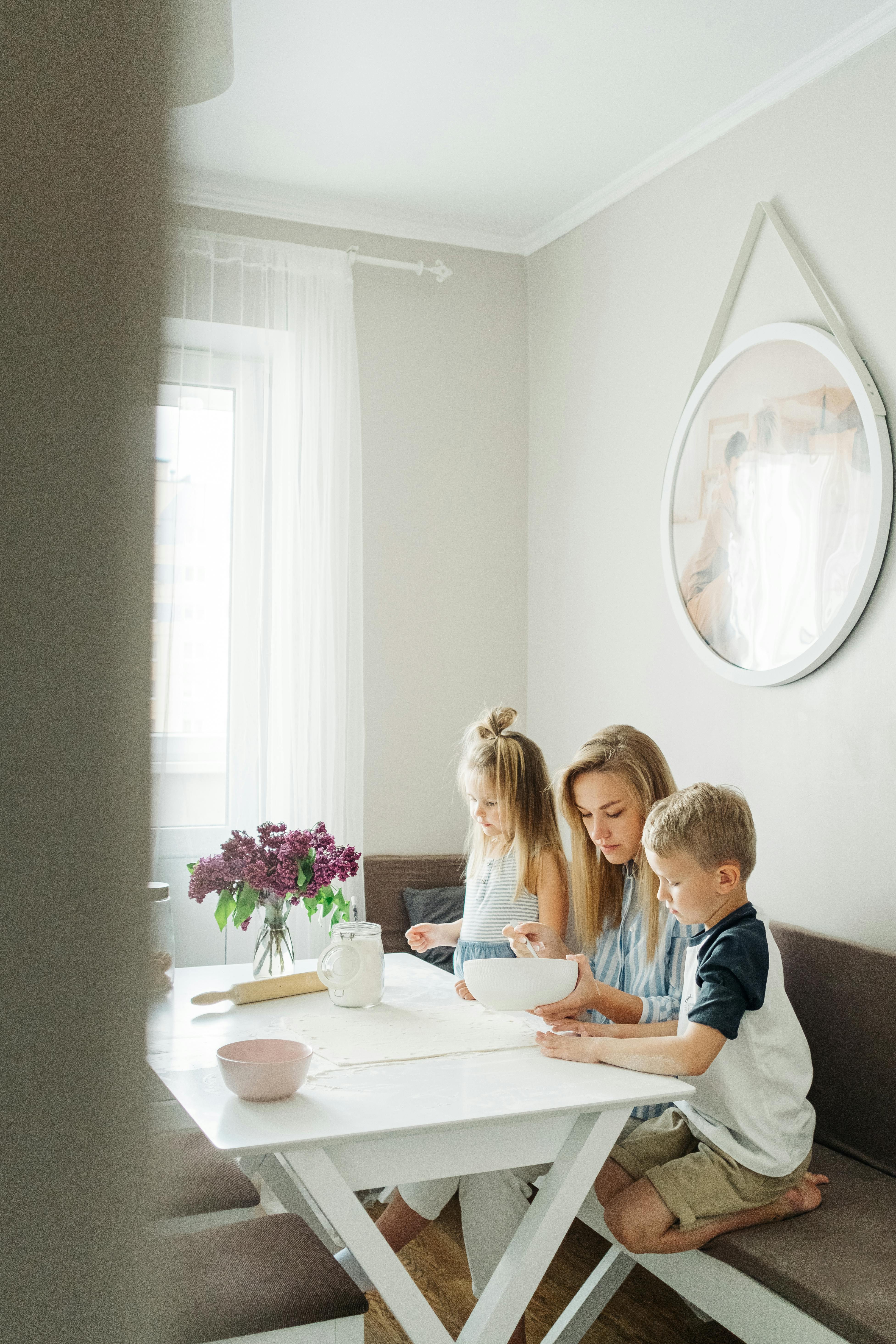 a woman preparing food with her kids while sitting on the couch