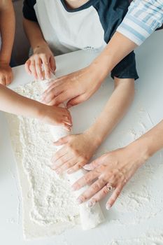 家人们愉快地合作，一起滚动面团，精心制作珍贵的厨房时刻