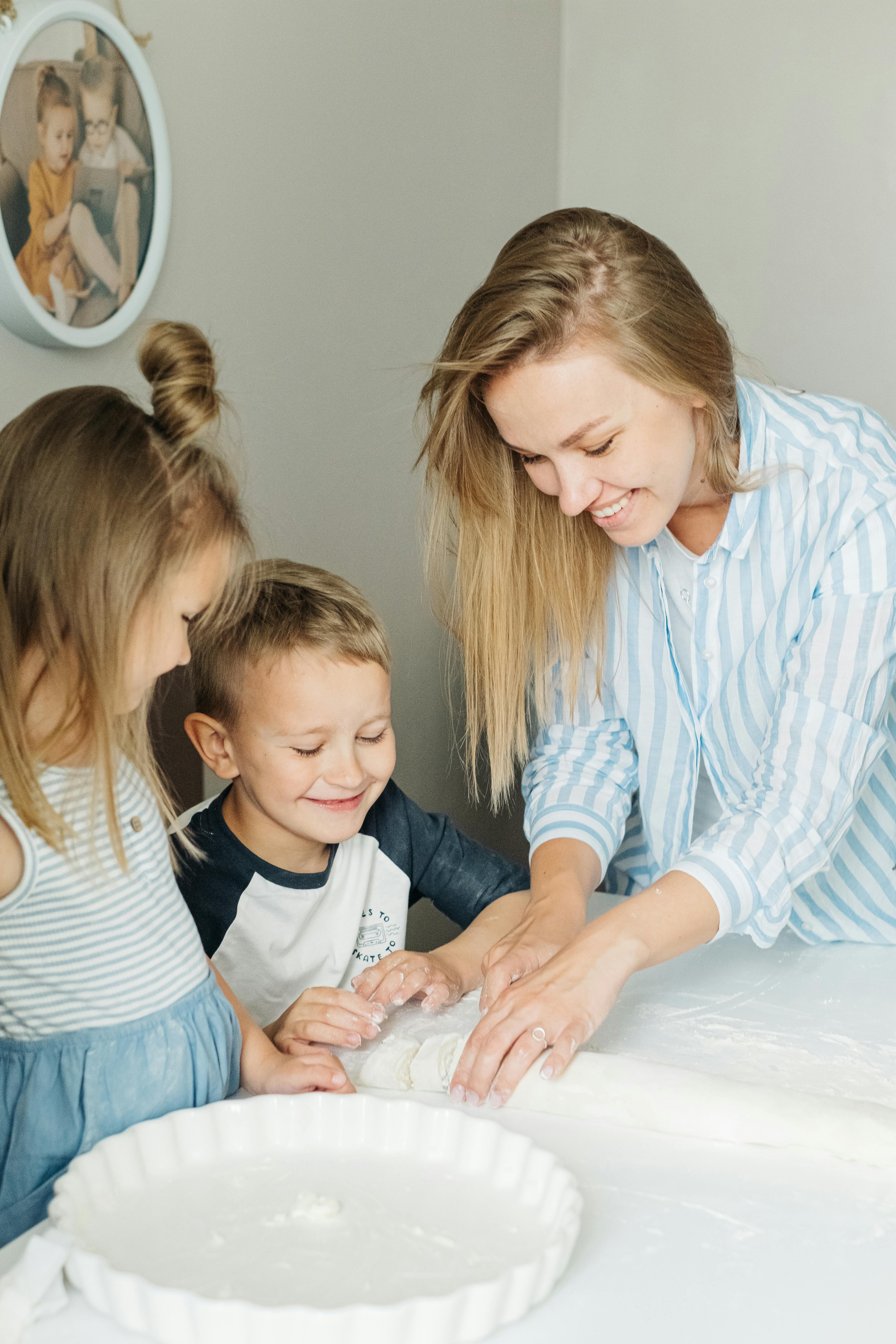 woman in blue and white striped long sleeve shirt holding girl in white long sleeve shirt