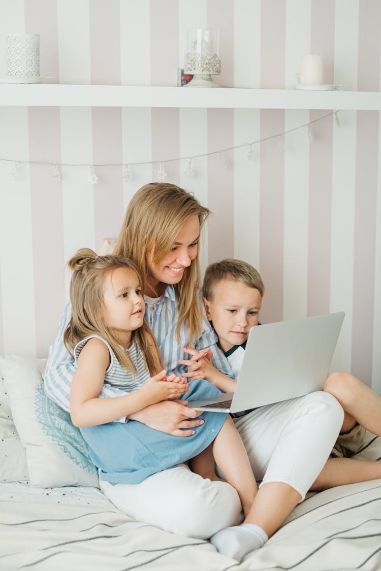 Mother And Her Children Watching On Laptop