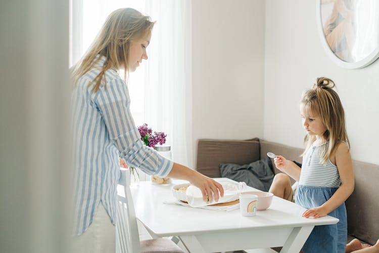 Mother Pouring Milk On A Cup