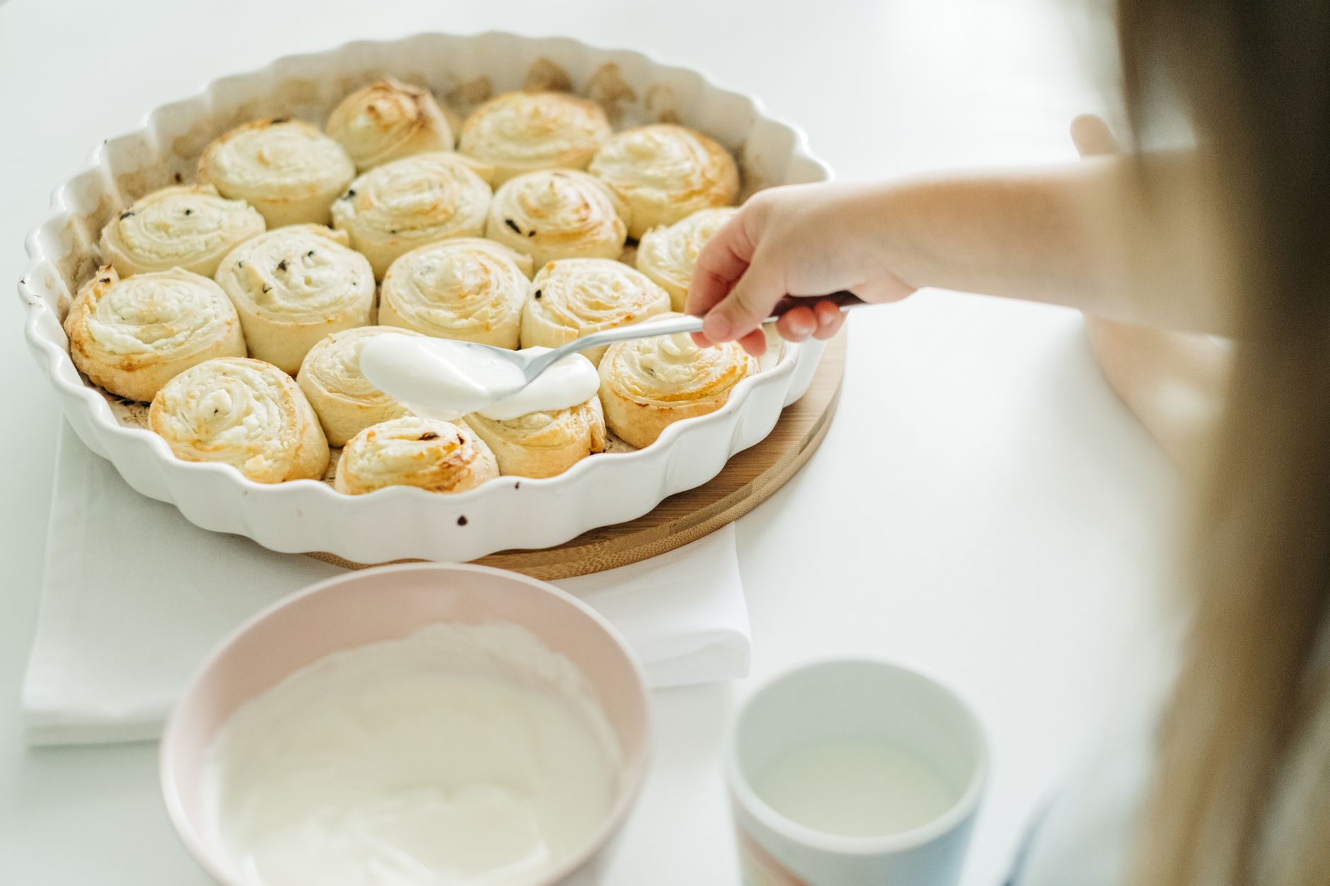 A tray of homemade cinnamon rolls fresh from the oven with glaze on top