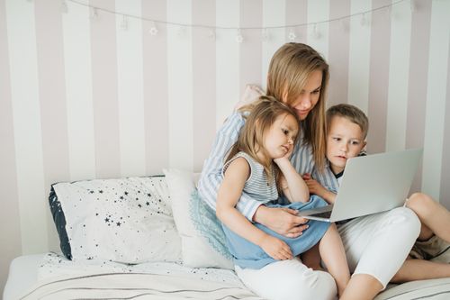 Free Mother and children bonding over a laptop at home, creating joyful family moments. Stock Photo