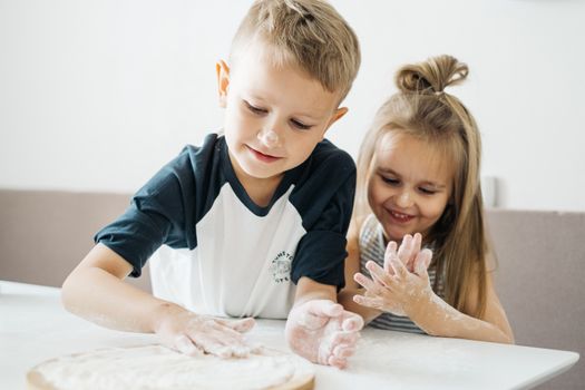 Boy and Girl Sitting on White Bed