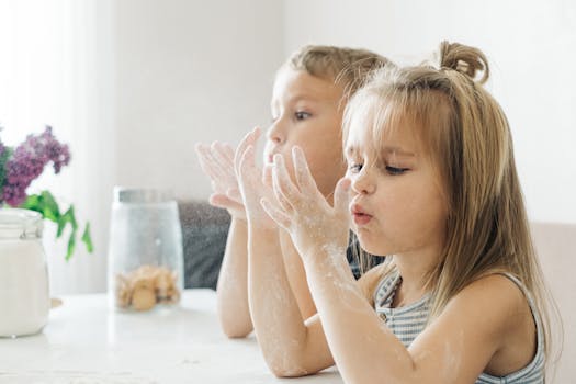 两个年幼的孩子在明亮的室内玩面粉