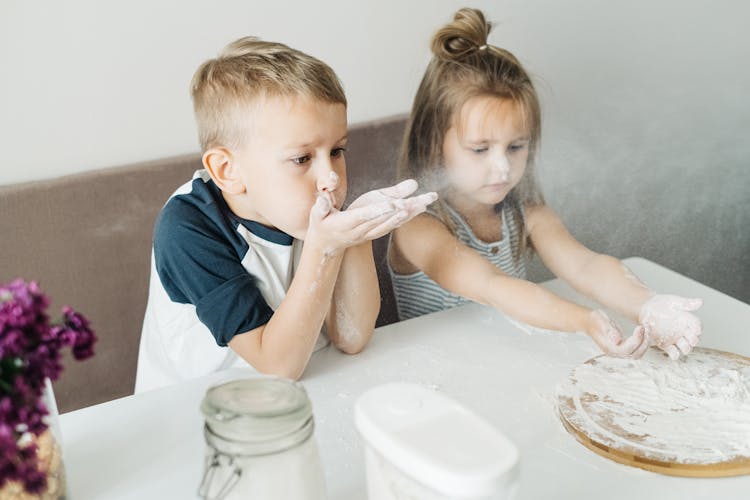 A Boy Blowing Off Flour On His Hands