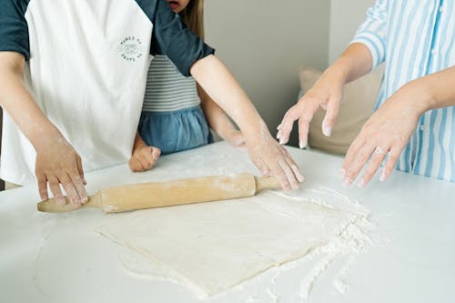 Free Hands of a Person Using a Rolling Pin on a Dough Stock Photo